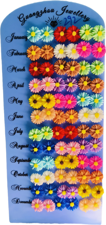 Daisy flower stud earrings display board showing multiple color options by month